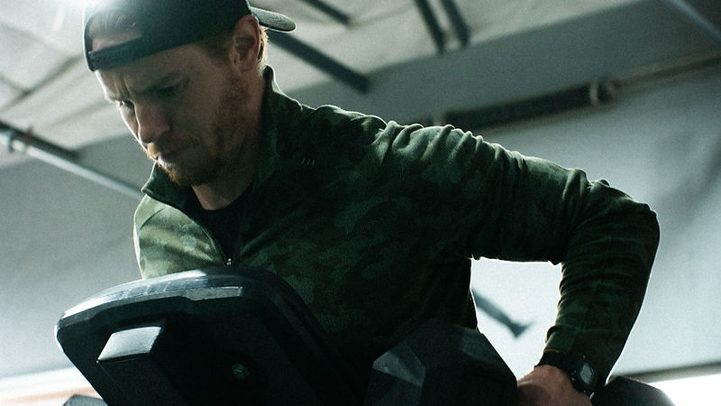 Athlete rowing dumbbells on an incline bench