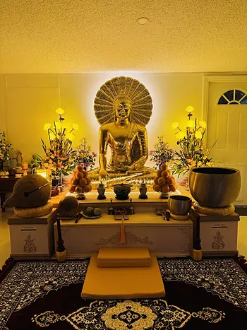 Tượng Phật dát vàng trên chánh điện trong ánh đèn ấm buổi tối