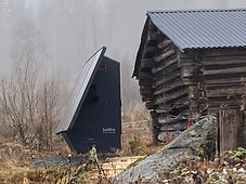 SoWin Kraftstasjon installert utendørs i tåkete skoglandskap ved en gammel tømmerhytte