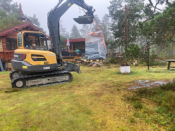 Volvo gravemaskin løfter innpakket SoWin-enhet på paller på en gresskledd eiendom
