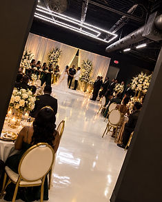A wedding ceremony set with floral arrangements and draping