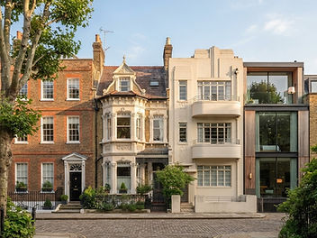 Street of four architectural styles side by side: a Georgian brick townhouse with sash windows, an ornate Victorian house with bay windows, a cream Art Deco building and a modern glass and timber house