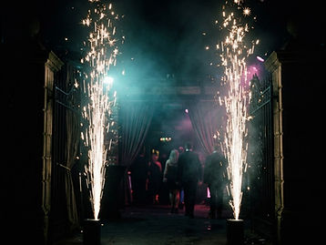 Fuentes de chispas frías iluminando una entrada en un salón oscuro