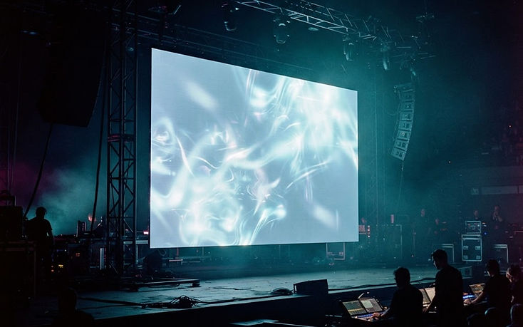 Pantalla de proyección iluminada sobre un escenario oscuro