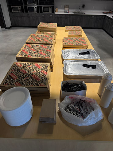 Pizza boxes and catering spread set up for an office event
