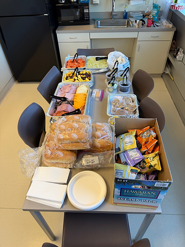 Full catering spread with subs, sides, and chips set up for an event