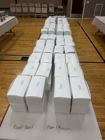 Sub sandwich boxes labeled and ready in a school gym