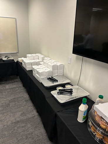Boxed lunches and sandwich trays set up for an office event
