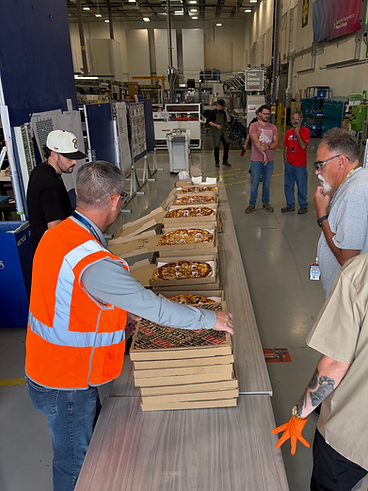 Crew serving fresh pizzas at a warehouse event