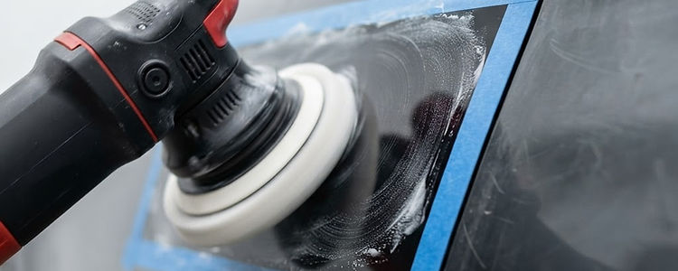 Machine polishing a section of car paint during paint correction