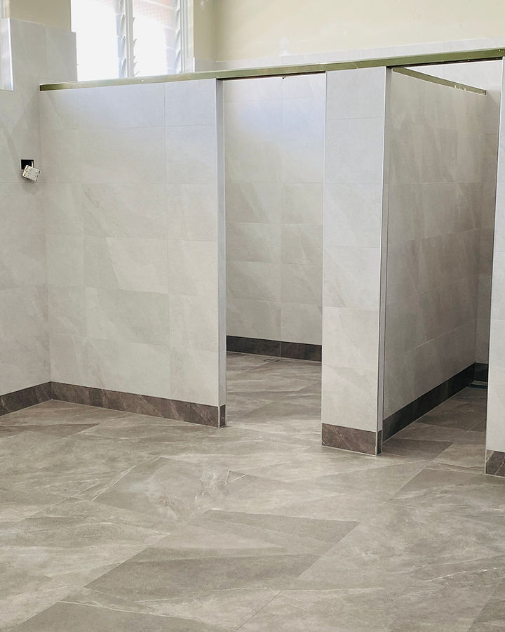 Craftsman setting a large-format marble tile in a luxury bathroom