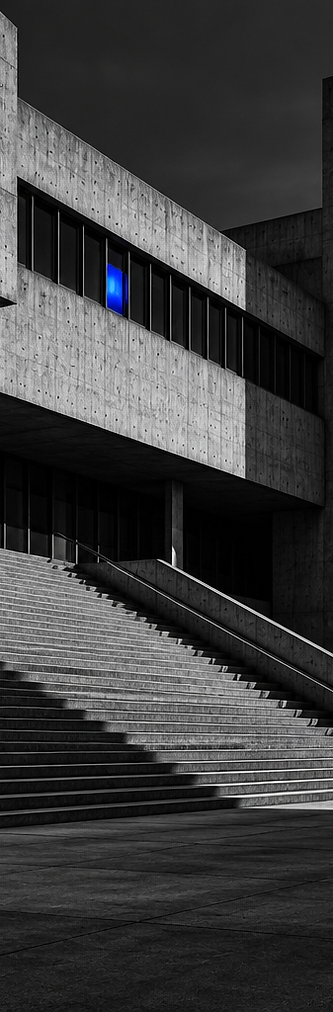 Black and white concrete building with a single blue light