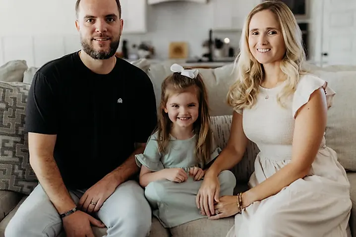 Drew with his wife and daughter sitting together at home