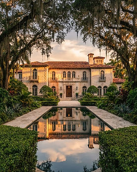 Mediterranean Revival estate in Coral Gables with a reflecting pool beneath a live oak canopy at golden hour