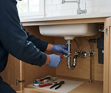Drain trap and water supply connections beneath a kitchen sink
