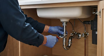 Drain trap and water supply connections beneath a kitchen sink