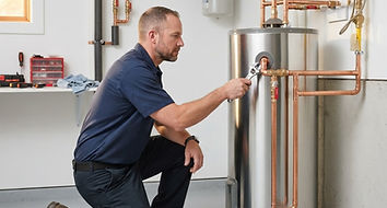 Technician inspecting residential water heater connections