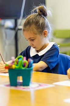 GCA students drawing at their classroom table