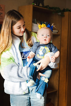 A GCA student holding a baby in Lions gear