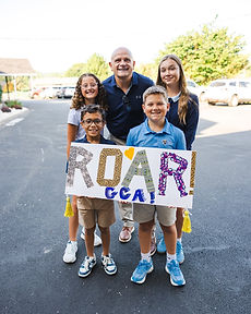 GCA students holding a ROAR sign with their principal