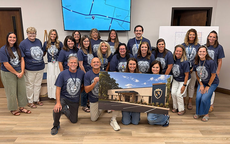 GCA faculty and staff holding a rendering of the new campus