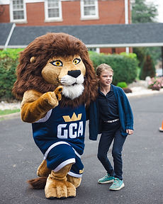 The GCA lion mascot with a student on the first day