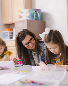 A GCA teacher helping students in the classroom