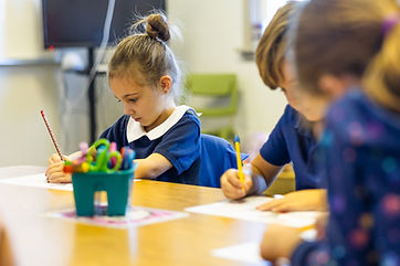 A GCA student writing at her desk
