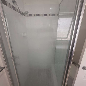 Shower glass before restoration with hard-water build-up