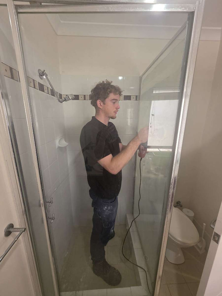 Divine Shine restoration artisan polishing a glass shower door