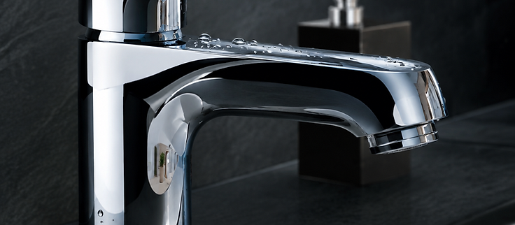 Polished chrome faucet reflecting a clean bathroom