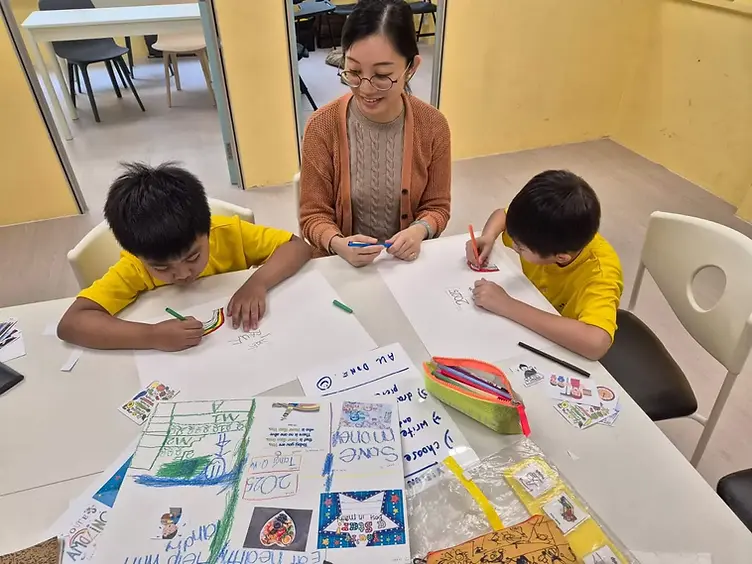 Starlight Centre teacher guiding two students through a hands-on learning activity