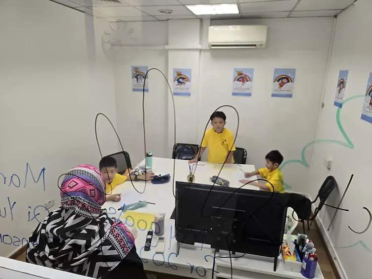 Starlight Centre students working with a teacher in a partitioned learning room