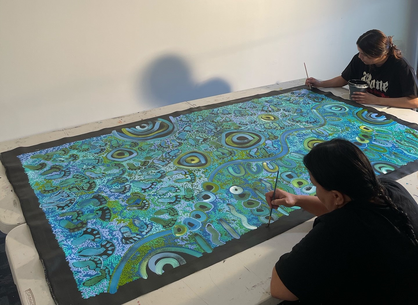 The artwork — a central pipeline and the footprints of community