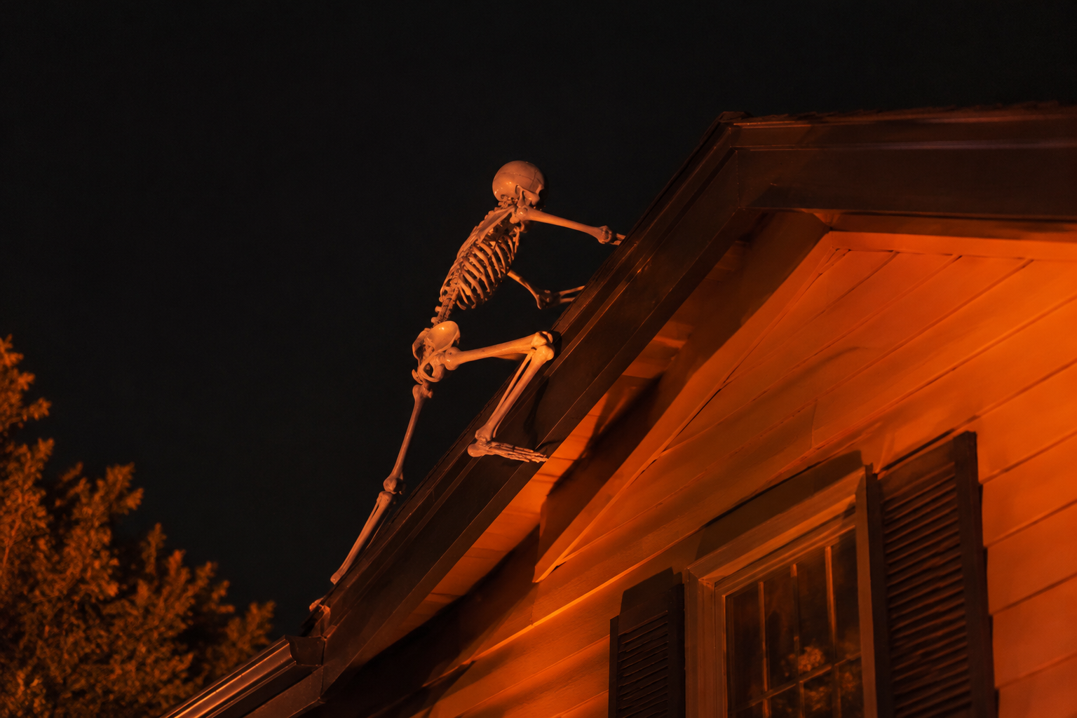 7. Skeleton Climbing the Roof - backyard Halloween party idea