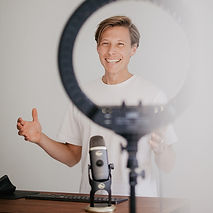 Seb de la Web professional web designer, Sebastiaan Gamelkoorn smiling behind a desk with a Blue Yeti microphone and keyboard, framed by a studio ring light for web design and content creation in the Netherlands (sebdelaweb-webdesigner.jpg)