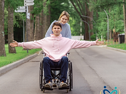 Jeune patient en fauteuil roulant sur un chemin arboré