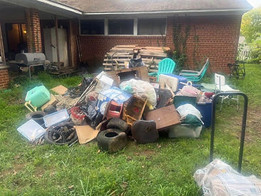 Tires, bins, boxes, and furniture piled up in the backyard