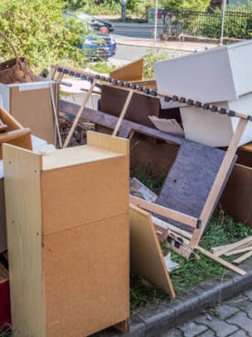 Old furniture and debris piled on a curb ready for junk removal