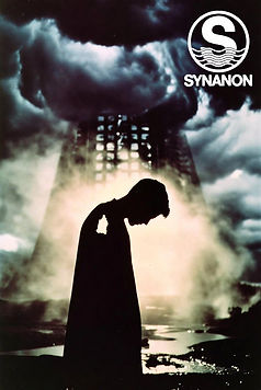 A figure in silhouette before a smoking tower, the Synanon mark in the corner of the frame.