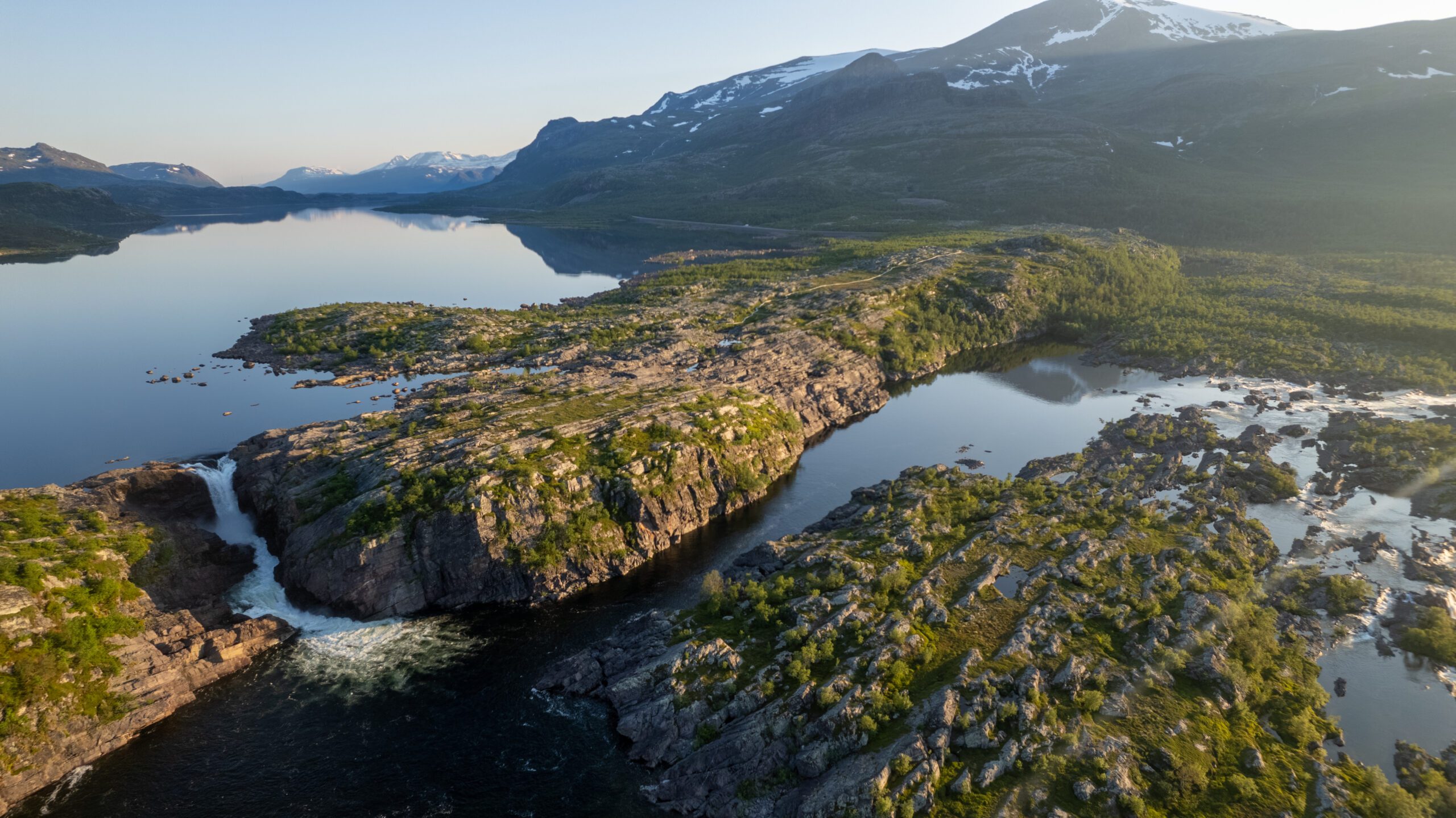 Flygfoto av älv och vattenfall i lappländsk fjällvärld