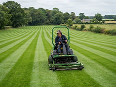 Ride-on mower cutting a large Norfolk lawn with crisp stripes