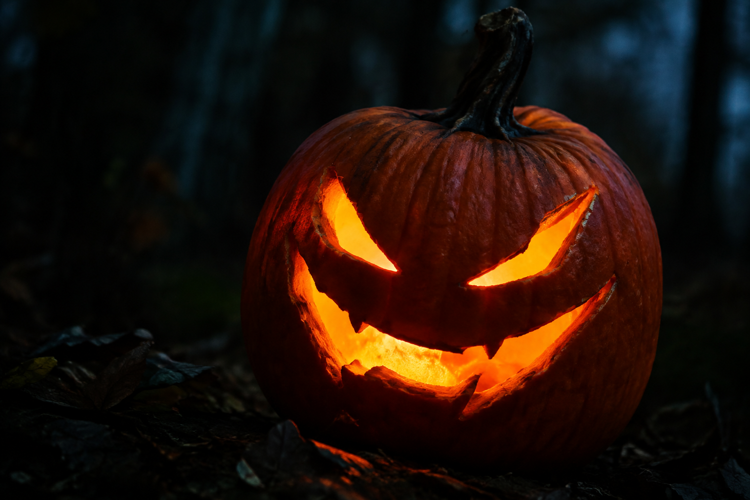 Sinister jack-o-lantern with slanted evil eyes and smirk in dark setting