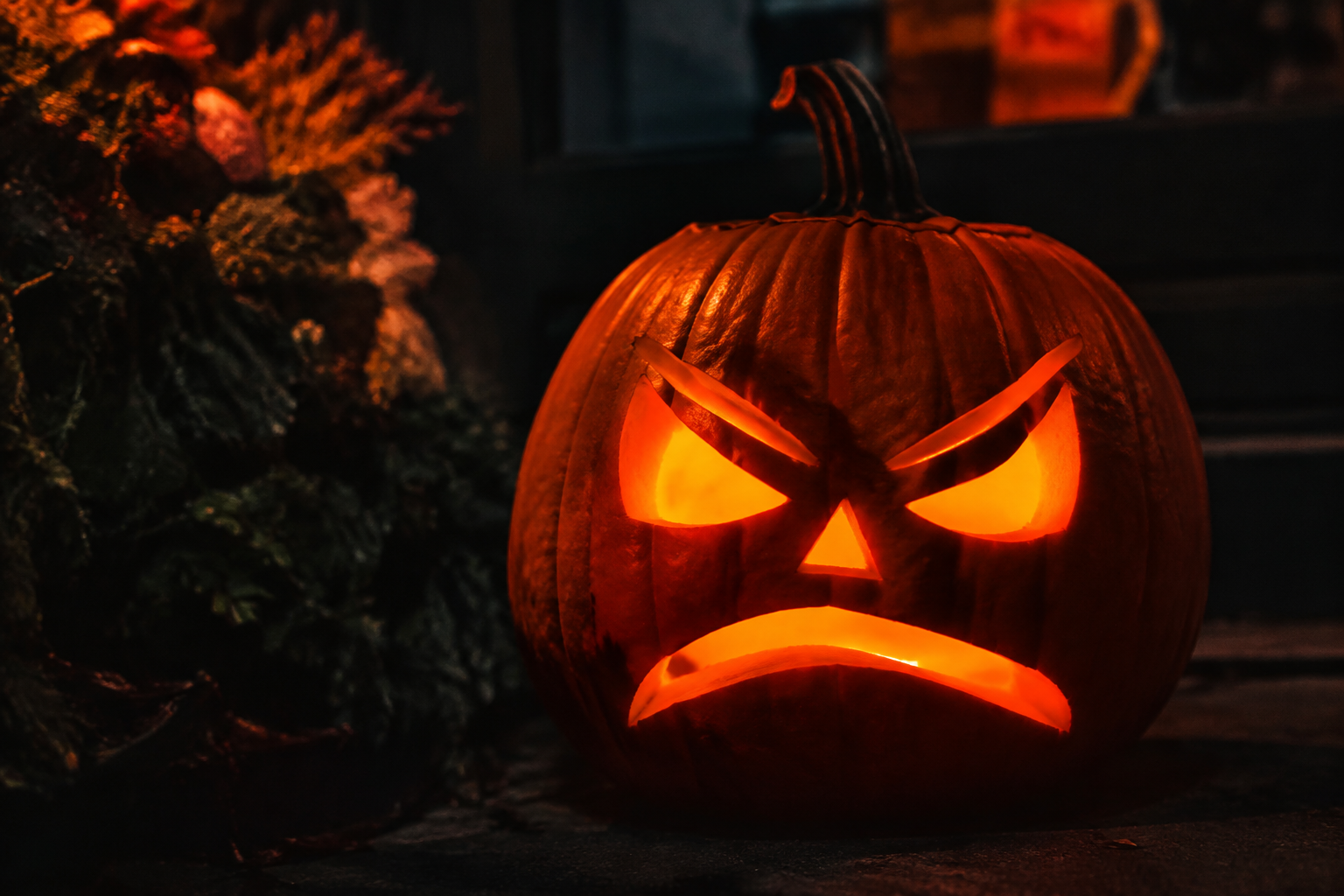 Spooky scowling jack-o-lantern with angry eyebrows at night