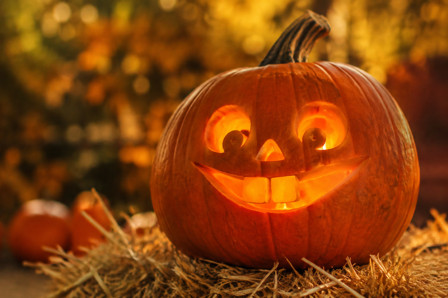 Buck-toothed jack-o-lantern with two big front teeth on hay bales