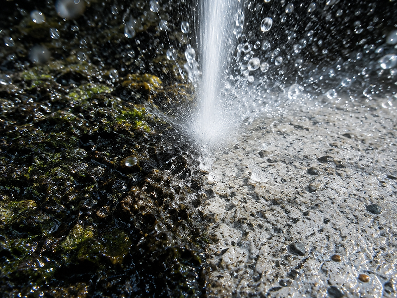 High-pressure water jet cleaning a weathered concrete surface