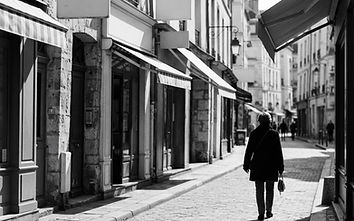 Black and white street photo of shop facades on a European high street