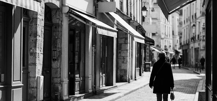 Black and white street photo of shop facades on a European high street