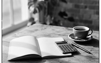 Black and white still life of a desk with a calculator and a notebook