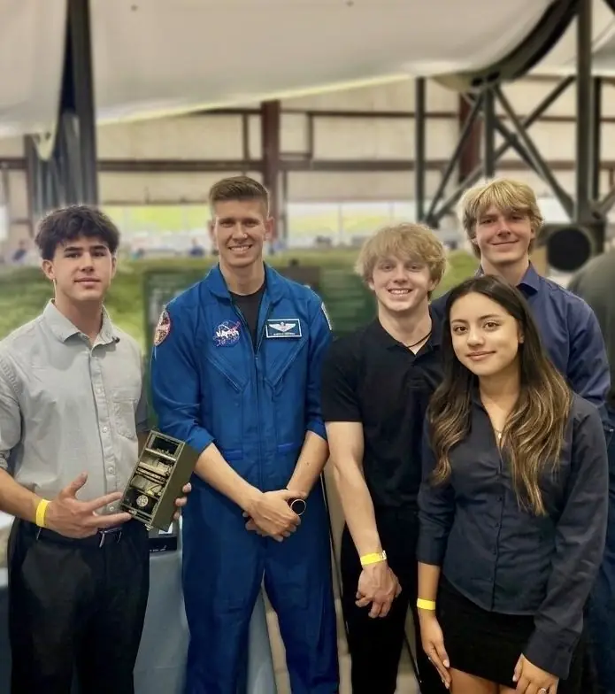 Our NASA HUNCH team with a NASA astronaut under the Saturn V rocket in Houston